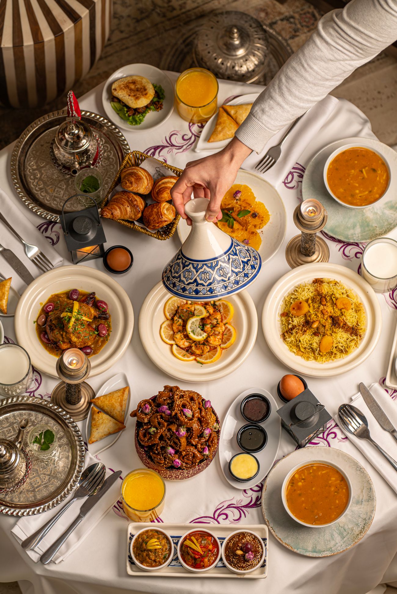 Een rijk gedekte Marokkaanse tafel met tajines, soep en verse gerechten